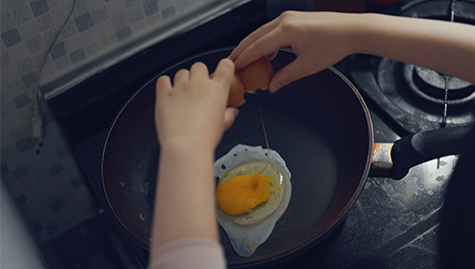 계란후라이를 하고있는 아동의 사진